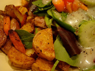 Close up of the roasted potatoes and carrots next to dressed salad