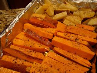 Sliced Sweet Potatoes and White Potatoes oiled and seasoned in foil lined pan