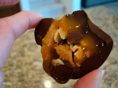 Hand holding High Raw Vegan Chocolate "Turtles" showing underside