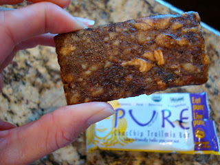 Hand holding Pure Brand Chocolate Chip Trail Mix Bar