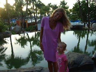 Woman and young girl at dusk standing in front of pool