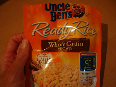 Hand holding Uncle Brand Whole Gran Brown Ready Rice package