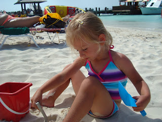 Young girl on beach building sand castle