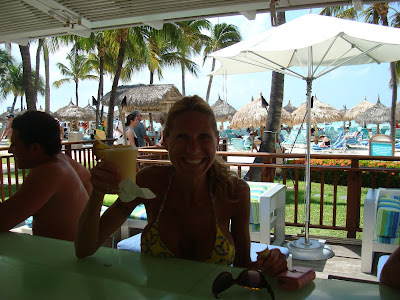 Woman sitting at outdoor bar holding a drink