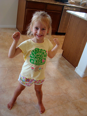 Young girl standing in kitchen flexing