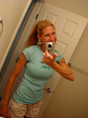 Woman showing off blue t-shirt in mirror