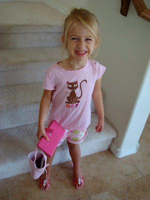 Young girl in high heels holding purse and pink handbag