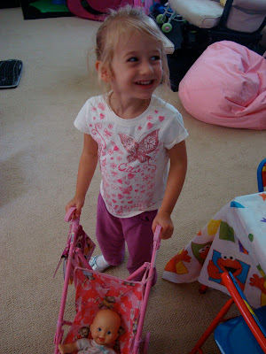 Young girl pushing around baby doll in stroller