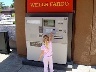 Young girl playing with ATM machine