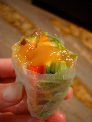 Side view of Fresh Vegan Spring Roll dipped in Peanut Sauce