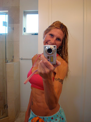 Woman showing abs and smiling in mirror