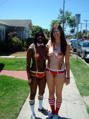 Two women on side walk with under wear suspenders and pasties