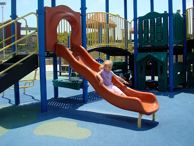 Young girl sliding down slide
