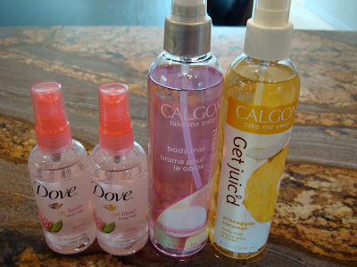 Four bottles of body spray on countertop