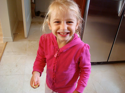 Young girl standing in kitchen smiling