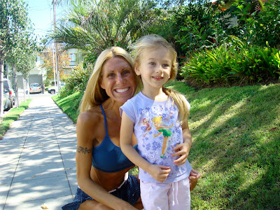 Woman in workout close with arm around young girl on sidewalk smiling - 5
