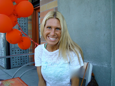 Woman sitting in chair with red balloons behind her