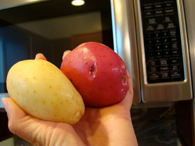 Two potatoes going into microwave