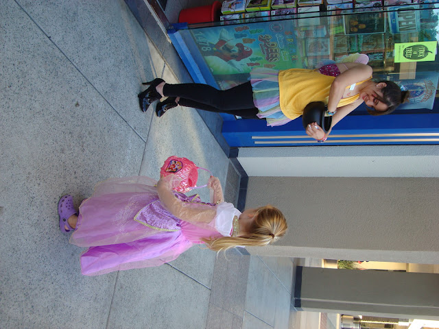 Young girl in costume trick-or-treating at mall