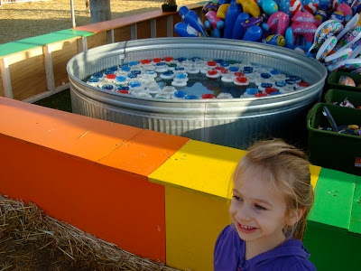 Young girl standing in front of ping pong toss game