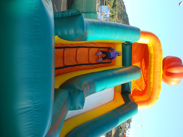 Young girl climbing up giant blow up slide