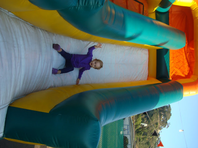 Young girl reaching the bottom of giant blow up slide
