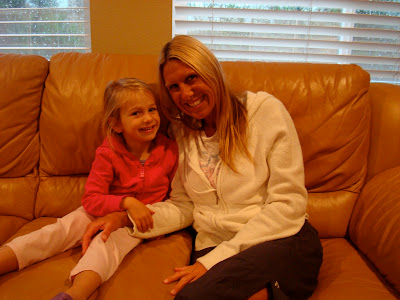 Young girl and woman sitting on couch smiling