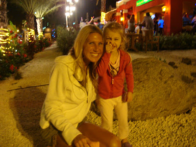 Woman and child standing outside next to rock smiling