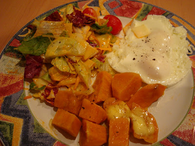 Eggs, sweet potatoes with salad on plate