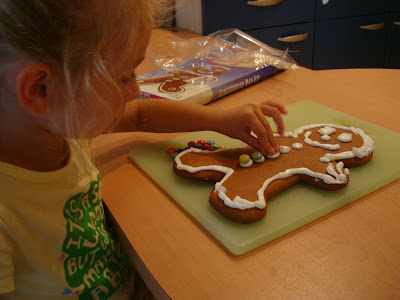 Young girl putting candy on gingerbread man