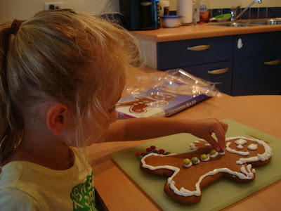 Young girl placing "buttons" on gingerbread man