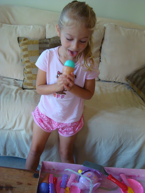Young girl pretending to eat fake toy ice cream cone