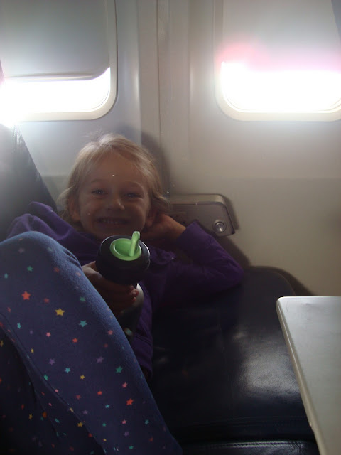 Young girl laying on airplane seat