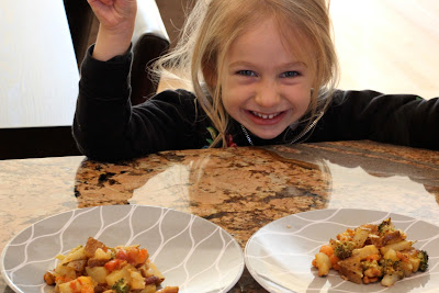 Young girl smiling in front of plates of Cheezy Vegetable Bake