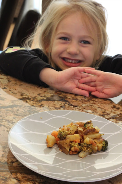 Young girl in front of plate of Cheezy Vegetable Bake
