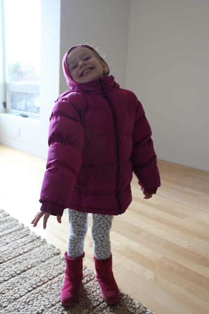 Young girl standing in puffer jacket and boots