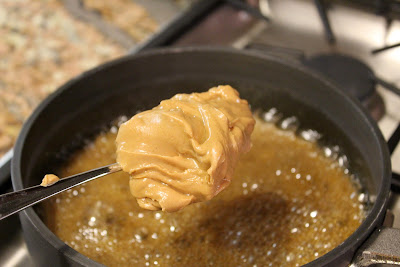 Scoop of peanut butter being added to butter mixture 