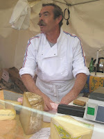 Frenchman with classic moustache selling cheese