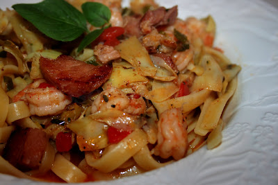 My Mama's Shrimp and Fettuccine recipe, made with shrimp and andouille sausage, cooked in a buttery sauce tossed with fettuccine, fresh herbs, artichokes and pimentos.