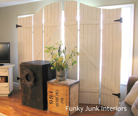 Learn how to easily build your own wooden gate window screens on a room divider with plank wood! Perfect for pet households and they resemble gates or barn doors! Click to full tutorial.