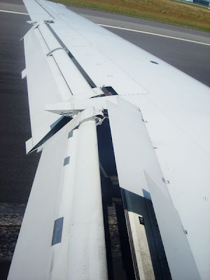 Un avión aterrizando con flaps y spoilers desplegados