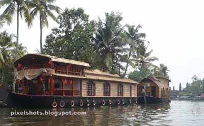 docked houseboats in kumarakom lake, boat journey through vembanadu lake, backwater tourist spots in kerala, kumarakom houseboats and boat journey, kerala houseboats, vembanadu tourism, tourist spots in kottayam