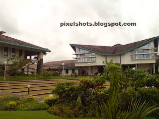 iim kozhikode kerala,photograph of the iim main building through the gardens