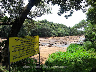 yellow caution board seen aside kallada river near thenmala ottakkal lookout,caution board of water authority saying danger zone of river,dont enter river,dangerous rivers of kerala,yellow danger caution board of kerala water authority