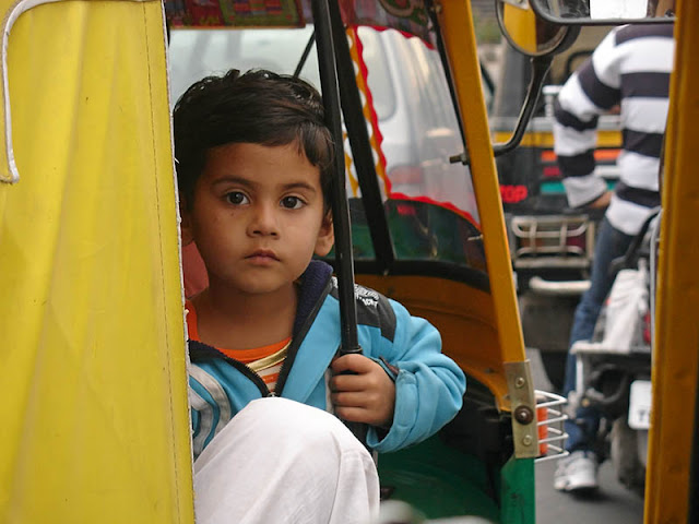 Le regard curieux d'un enfant à bord d'un rickshaw à Jaipur, Inde
