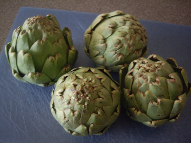 Artichokes on a cutting board. 