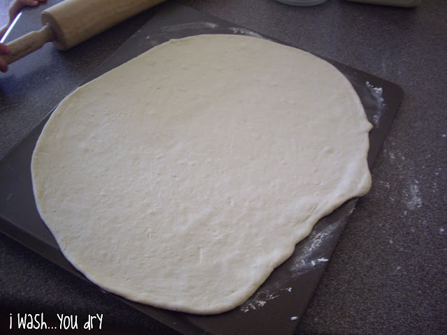 Pizza dough rolled out on a cookie sheet. 