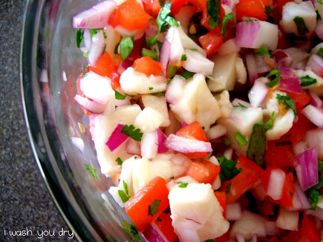 Close up of diced fish and veggies in a bowl.