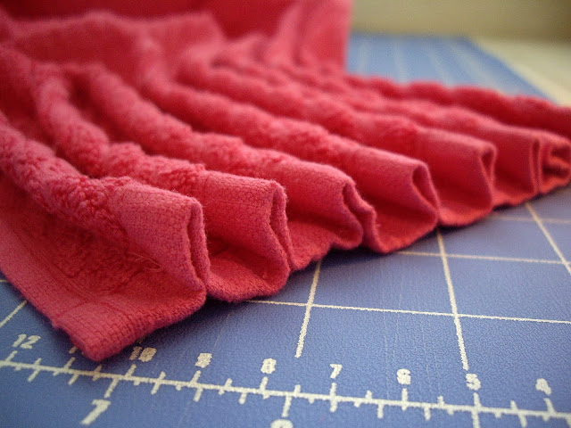 A close up of many pleats on the top of a dishtowel. 