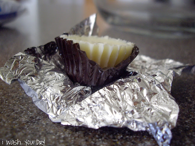 A close up of an open and unwrapped white chocolate peanut butter cup. 